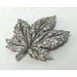 A fine diamond and platinum brooch in the form of a maple leaf, length 54mm, approx 17.40gms. This
