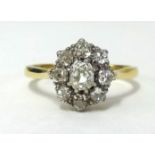 An 18ct diamond cluster ring, set with 9 old cut diamonds, the centre stone approx .50 cts, finger