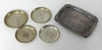 Four silver coasters and a silver plated tray.