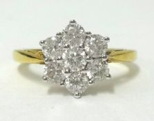 A 18ct gold daisy ring, set with an arrangement of 7 round cut diamonds, finger size N.