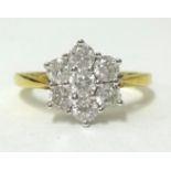 A 18ct gold daisy ring, set with an arrangement of 7 round cut diamonds, finger size N.