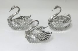 A set of three Continental silver and cut glass sweet meat dishes, modelled as swans (3).
