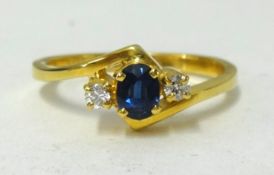 A 18ct yellow gold ring set with a sapphire and diamonds, 3 stones, finger size P.