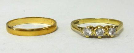 A three stone diamond ring stamped 750, approx 2.4gms together with a gold wedding band stamped 750,