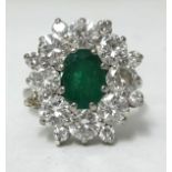 An 18ct white gold diamond and emerald cluster ring, having an oval cut emerald approx 1.00ct,