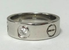 Cartier, a white gold Santos diamond set band ring, stamped '.750 Cartier', finger size L, approx