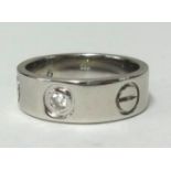 Cartier, a white gold Santos diamond set band ring, stamped '.750 Cartier', finger size L, approx