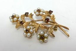 A 9ct flower brooch, set with garnets and pearls, length 55mm.
