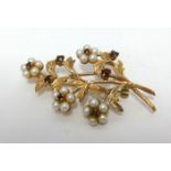 A 9ct flower brooch, set with garnets and pearls, length 55mm.