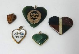 Four heart shaped pendants and one hard stone pendant.