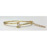 An 18ct yellow gold bangle set with a single round cut diamond, approx 7.60gms.