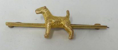A 9ct gold bar brooch surmounted by a Highland Terrier.