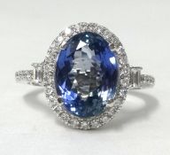 A 14ct white and diamond ring set with a oval cut tanzanite, approx 4.14cts, the diamonds approx 0.