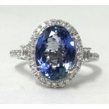 A 14ct white and diamond ring set with a oval cut tanzanite, approx 4.14cts, the diamonds approx 0.