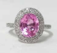 A white gold and diamond ring set with an oval cut pink sapphire approx 3.10cts, diamonds approx 0.