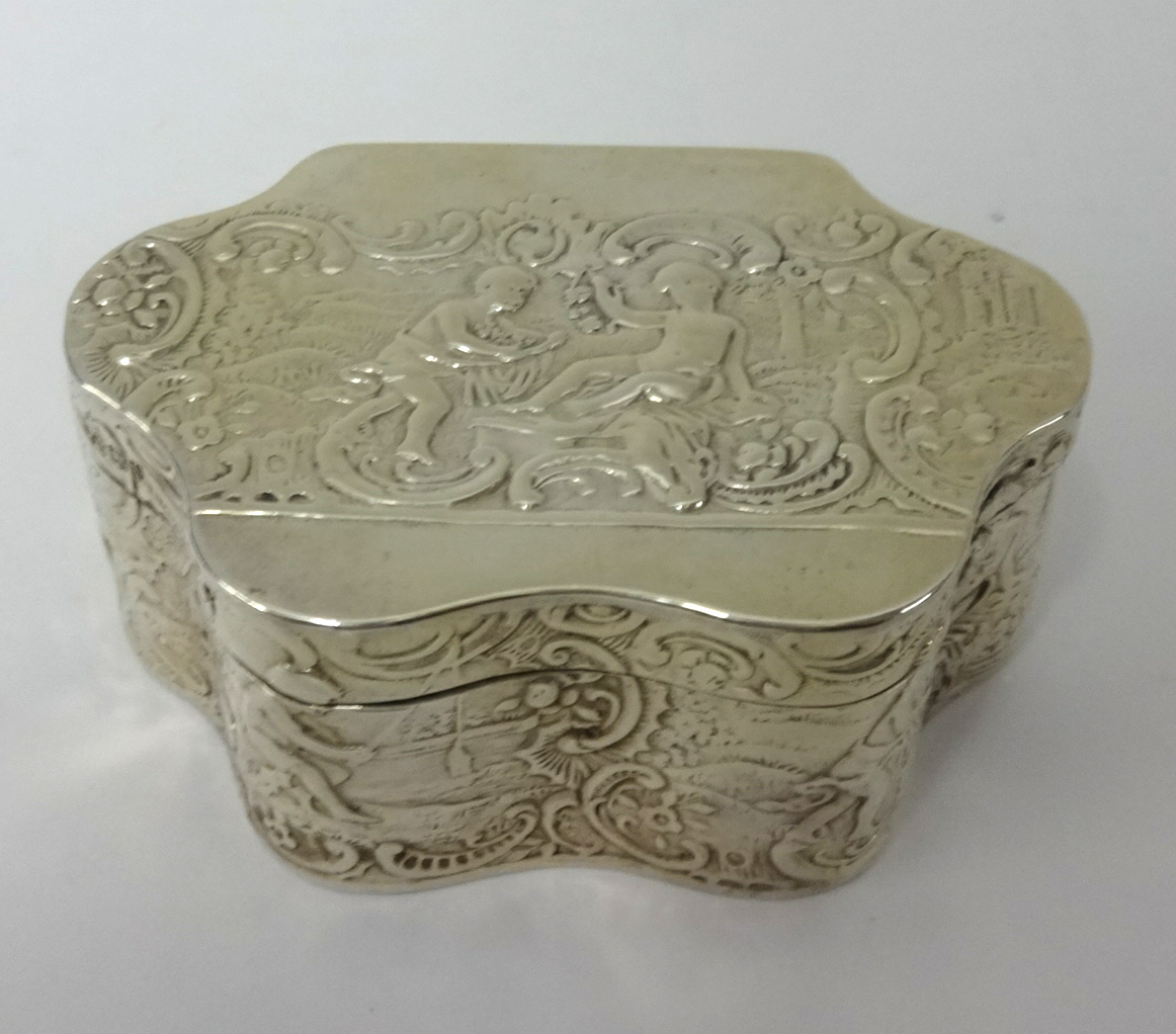 A silver box of wavy edge outline embossed with scrollwork and figures, circa 1895, approx 71.4gms.