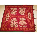 A hand-embroidered ceremonial blanket, thought to be Nepalese and with a red ground, stitched with