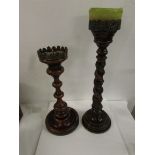 Two turned mahogany candle stands on circular bases, the taller (57cm) carved with a continuous long