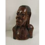 Carved wooden tribal style head and shoulders bust of woman, with red and black staining to the