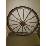 A fourteen-spoke wooden wagon wheel bound in iron and rubber, the bearing marked Woodcock & Son