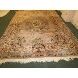 A large Chinese embossed woollen rug, pale ground with foliate border and oval central medallion (