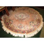 PALE PINK GROUND CIRCULAR FLORAL DESIGN FLOOR RUG WITH TASSELLED EDGE (APPROXIMATELY 194CM