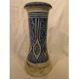 A pottery cylinder of waisted form and open to both ends, glazed in blue on white with a stylized