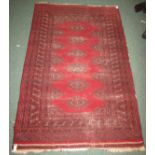 A 20th century red ground rug with ten margins, six whole medallions and part medallions around