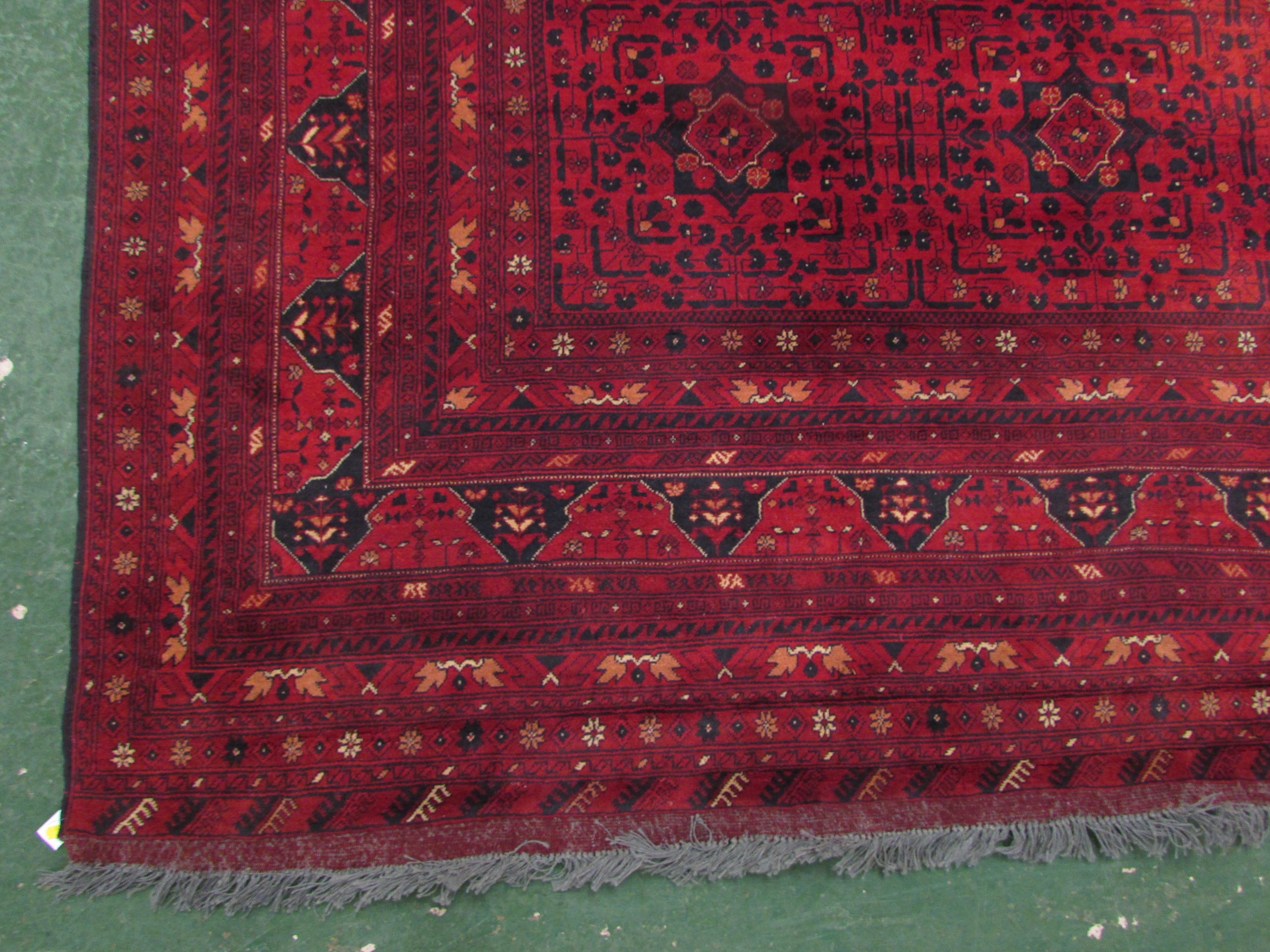 A good quality 20th century Afghan Kunduz red ground machine made rug with twelve small margins, - Image 2 of 3