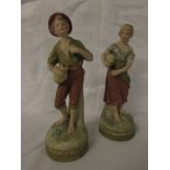 Two corresponding Royal Dux figures of young man and woman with flasks and drinking cups, on