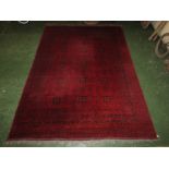 A good quality 20th century Afghan Kunduz red ground machine made rug with sixteen margins, blue
