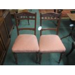 Pair of Edwardian red walnut side chairs with carved back rails, turned front legs, the horsehair