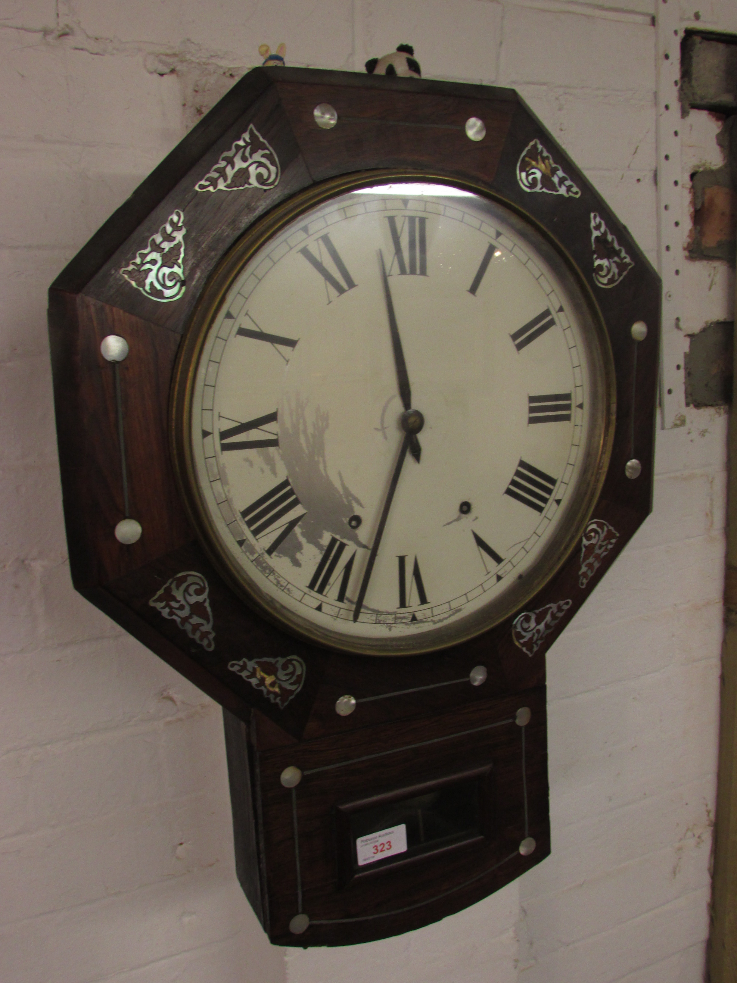 A Victorian eight-day striking wall clock. The octagonal case is of rosewood veneer and inlaid