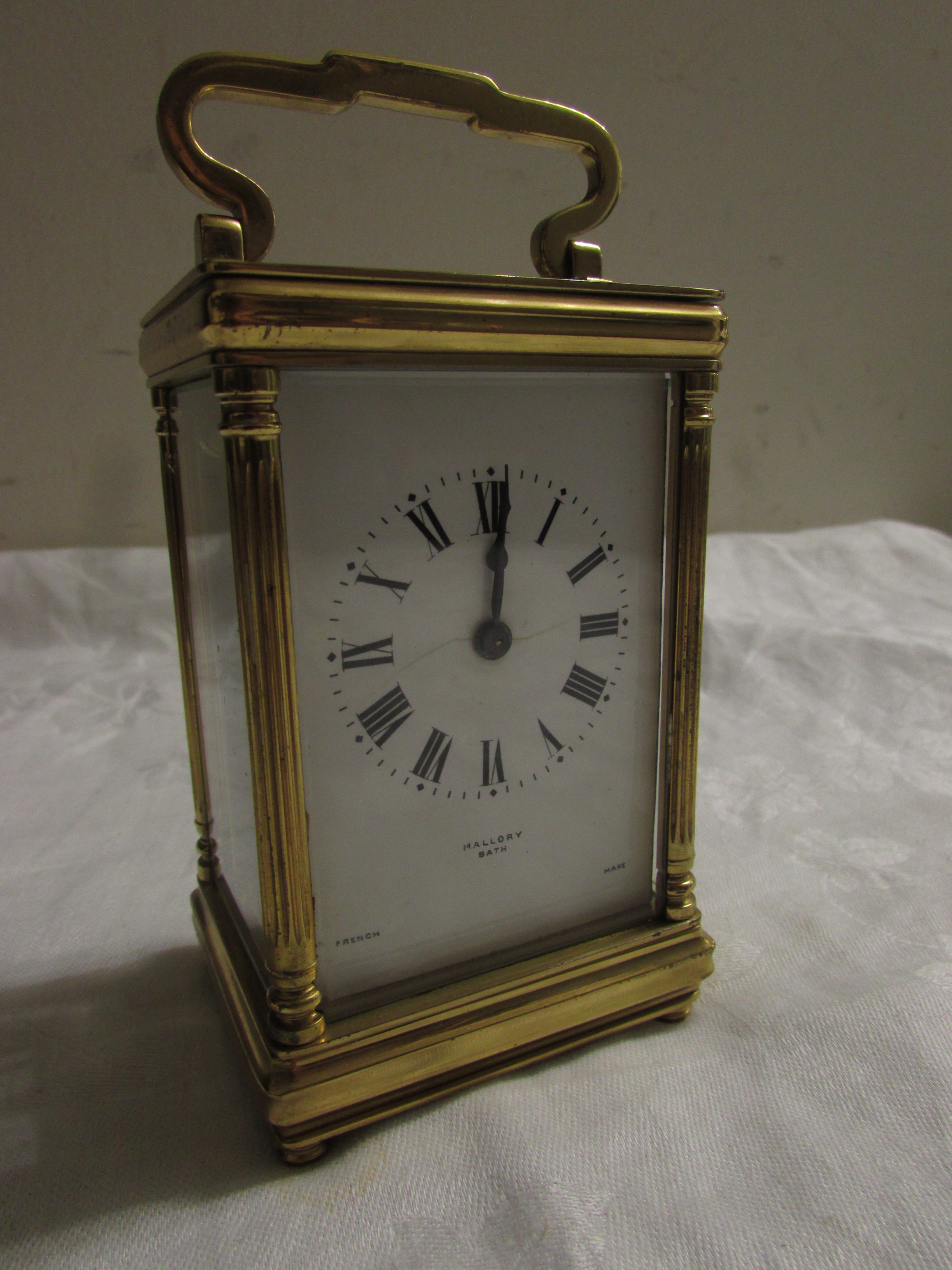 Brass carriage clock signed Mallory of Bath, French movement, (12cm x 7.5cm x 6cm) in original red