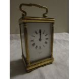 Brass carriage clock signed Mallory of Bath, French movement, (12cm x 7.5cm x 6cm) in original red