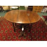 Oak oval gate leg table on bobbin turned supports with trestle base, each side with double wavy-