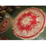 TWO CIRCULAR RED AND CREAM GROUND FLOOR RUGS WITH TASSELLED EDGES