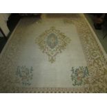 An embossed Indian cream ground rug with central floral feature flanked by a large border of stylize