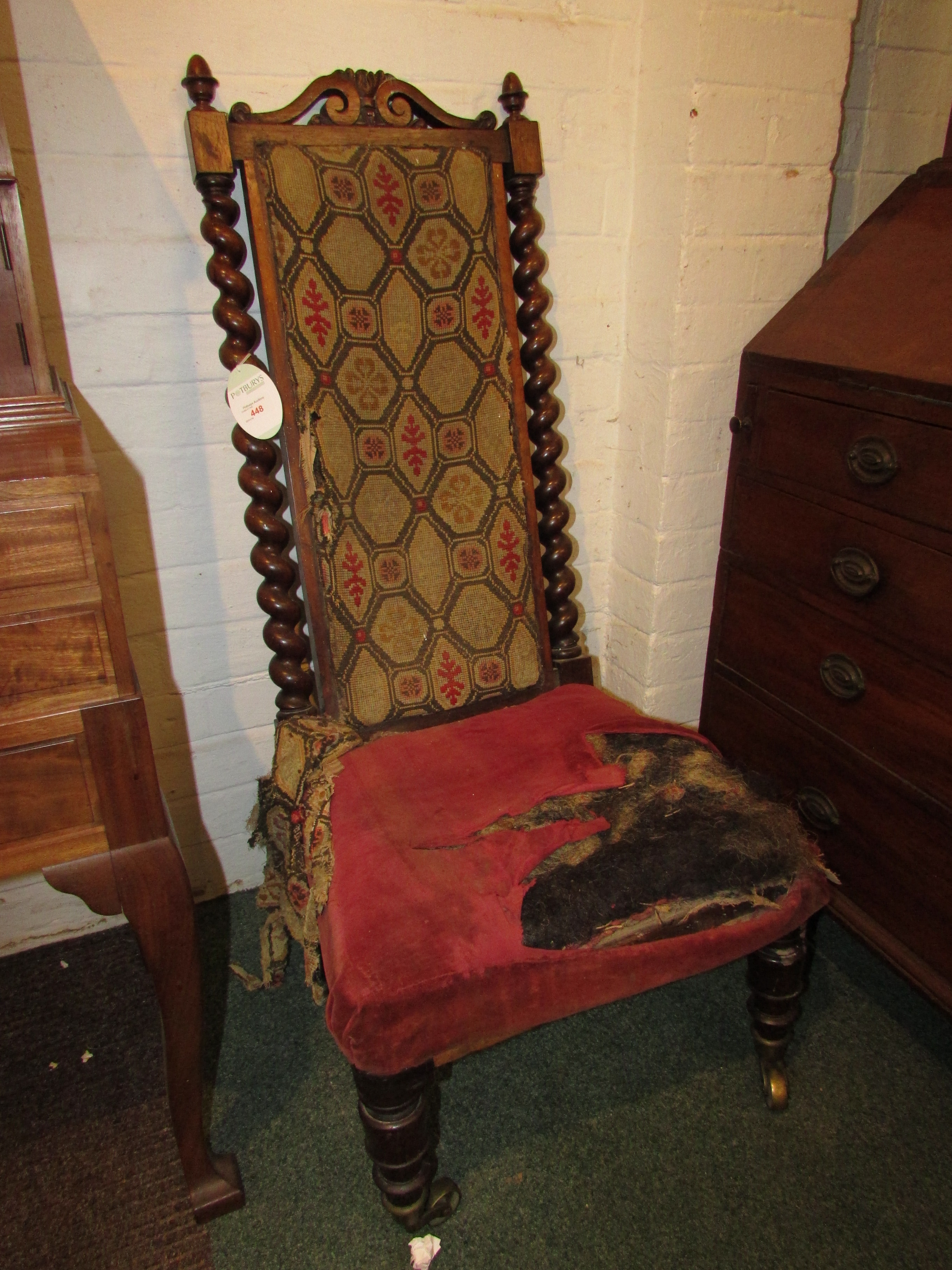 An early 19th century oak framed long back chair with barley twist side supports and central