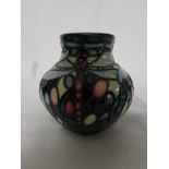 Moorcroft vase of squat form, green ground graduating to purple with piped decoration of three