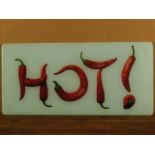 A 1960s/70s hot plate depicting the word HOT! in chillies