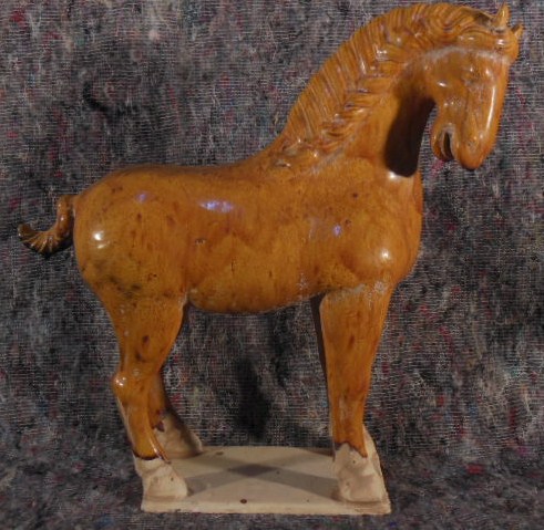 A glazed terra cotta figure of a horse. 40cm high