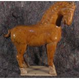 A glazed terra cotta figure of a horse. 40cm high