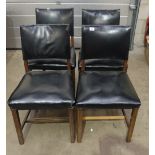 Four oak and black vinyl office chairs