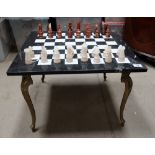 Marble topped chess board table on brass legs together with soft stone chess set