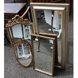 A collection of four modern wall mirrors.