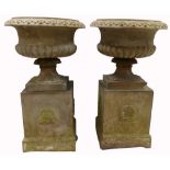 A pair of quality cast stone urns on bases,