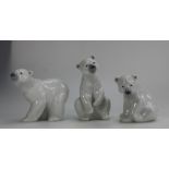 A collection of Lladro polar bears, two seated and one walking,