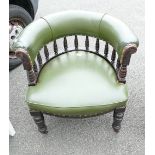 Green leather Captains chair with floral carvings.