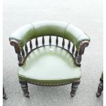 Green leather Captains arm chair with floral carvings.